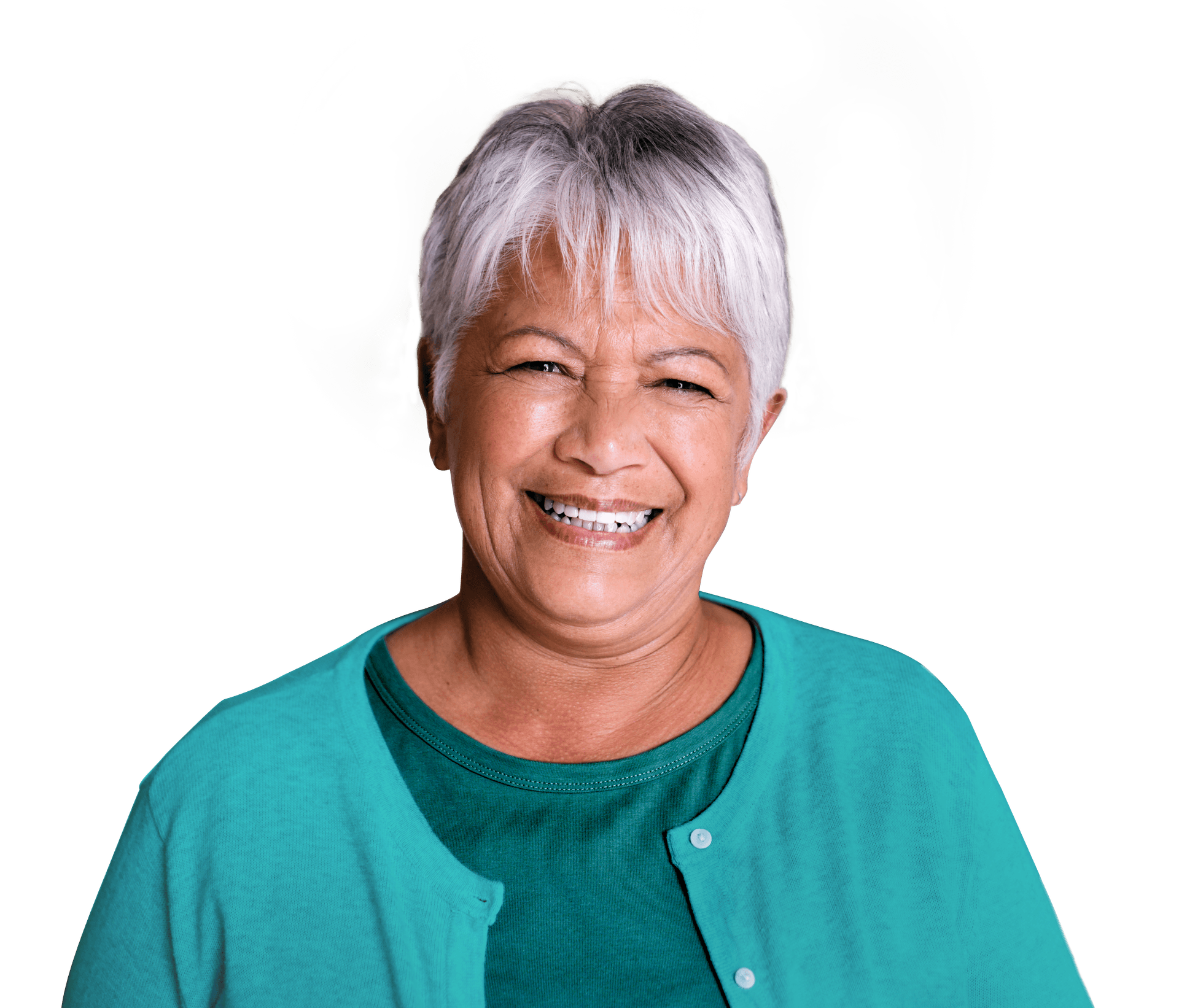 Mulher jovem de cabelos curtos e loiros sorrindo amplamente, vestindo um moletom verde e um relógio azul no pulso. Ela aponta para suas bochechas com ambos os dedos indicadores, transmitindo alegria e positividade.